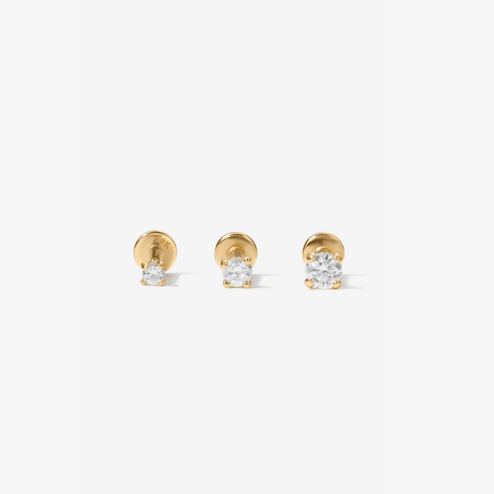 Three gold stud earrings with clear lab diamonds, arranged horizontally on a light gray background.