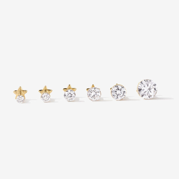 Six Vince gold round lab diamond studs arranged from smallest to largest.