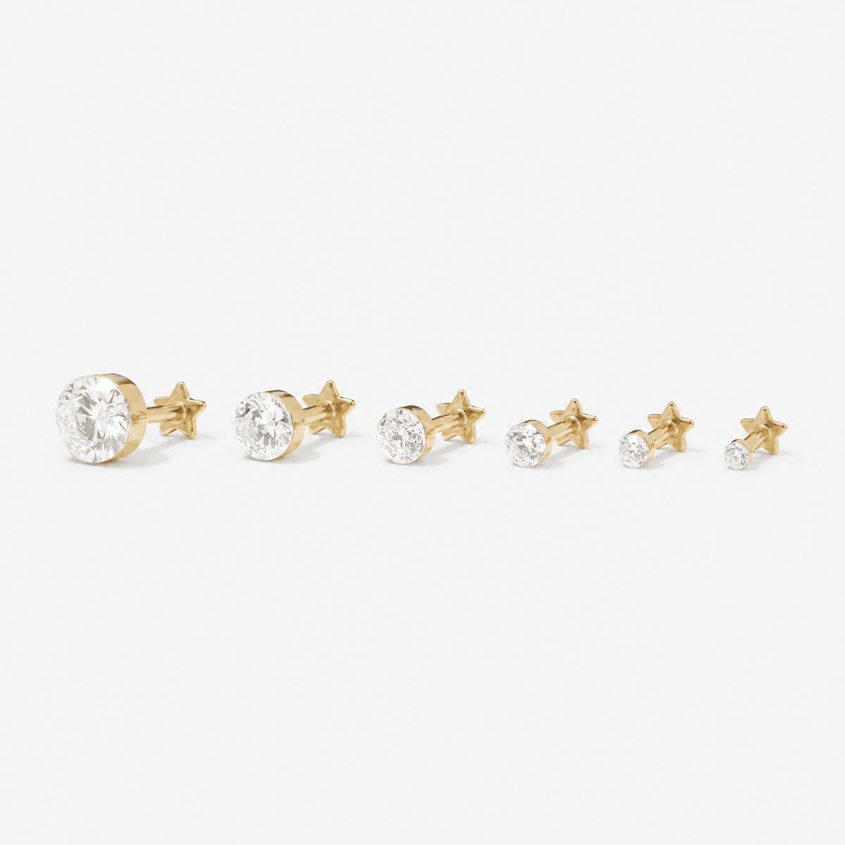 Six gold round lab-grown diamond studs arranged by size.