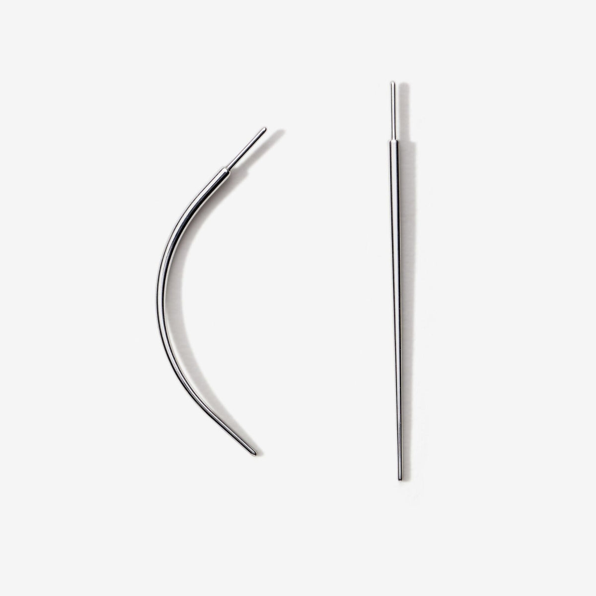 Two metal piercing tapers, one curved and one straight.